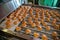 Baking production line. Cookies in form of hearts after glaze coating on conveyor