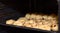 Baking sheet with pies and buns in an oven, the beginning of baking