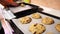 Baking sheet with ready-made cookies is next to a baking sheet with dough balls