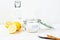 Baking soda in jar, vinegar, lemon, wooden spoon on a white background. The concept of removing stains on clothes