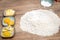 Baking soda or powder on wooden table, eggs, butter and lemon on