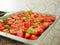 Baking tomatoes. Dried tomatoes in a baking sheet and spatula. strewn with seasonings and herbs
