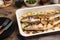 Baking tray with delicious baked sea bass fish and potatoes on wooden table