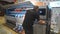 Baku, Azerbaijan-June 20, 2019: a male cameraman prints a photo on a large-format printer. A large format Printer inkjet