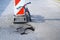 Balance bike push bike lean against detour alert traffic sign near pothole on asphalt street with