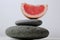 The balance of harmony is a piece of grapefruit fruit share lying on the gray stones. A tower of stones and food. meditation