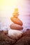 Balance, relaxation and wellness: Stone cairn outside, ocean in the blurry background. Sunshine