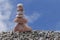 Balance stone on pile rock with blue sky background.