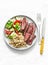 Balanced lunch - medium roast steak, vegetable salad and bulgur on a light background, top view