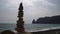 Balanced pebble pyramid on the beach on cloudy day. Abstract Sea bokeh on the background. Selective focus. Zen stones on