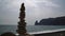 Balanced pebble pyramid on the beach on cloudy day. Abstract Sea bokeh on the background. Selective focus. Zen stones on