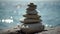 Balanced pebble pyramid on the beach on a sunny day. Abstract Sea bokeh on the background. Selective focus. Zen stones