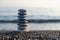 Balanced pebble pyramid silhouette on the beach.