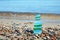 balanced pyramid of glass bottle fragments polished by the sea against the background of the oncoming wave