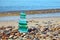 Balanced pyramid of glass bottle fragments polished by sea on shore of sandy pebble beach