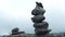 Balanced Rock Stones Stacked on Top of Each Other. Hierarchy and Balance. Pyramid of Stones on the Background of a Foggy