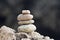 Balanced stacked stones or pebbles on a white sand beach