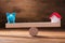 Balancing Of Piggybank And House Model On The Wooden Seesaw