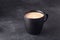 Balck ceramic mug of fresh hot coffee on on dark stone background. Copy space for your text