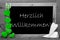 Balckboard With Green Heart Decoration, Text Herzlich Willkommen Means Welcome