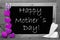 Balckboard With Purple Heart Decoration, Text Happy Mothers Day, Gray Wooden Background