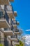 Balconies of a residential building against blue sky and snowy mountain