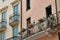 balconies on the tenement house, wooden shutters, cactus pots, iron balconies, salmon facade