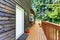 Balcony house exterior with wooden trim and flowers pots.