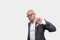 Bald adult man with glasses in a striped jacket makes the gesture thumbs down