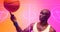 Bald african american basketball player spinning ball on finger over illuminated basketball court