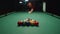 Bald bearded man breaks the pyramid of balls by hitting the white cue ball with the cue close up. Billiard player starts