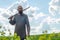 Bald bearded man in  metal chain mail over  linen shirt stands in the middle of  field, holding a sword. Militant look. Blurred