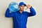 Bald courier man with beard holding a gallon bottle of water for delivery with angry face, negative sign showing dislike with