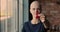 Bald female cancer patient holding red ribbon closeup view