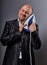 Bald fun happy comic business man holding the home iron near the face with love in suit on grey background. Closeup portrait.