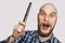 Bald funny surprised guy with open mouth, beard and with a comb in his hands, isolated