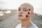 Bald girl wearing heart stickers with city on background - Main focus on right eye