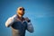 Bald Guy with a stylish beard and sunglasses on a sky background during sunset. Concept of success and will