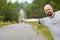 Bald-headed man hitching on road