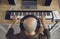 Bald headed musician in headphones recording music he& x27;s playing on MIDI keyboard