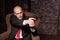 Bald killer in suit and red tie aims a pistol