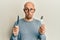 Bald man with beard holding fork and knife ready to eat depressed and worry for distress, crying angry and afraid