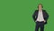 Bald man in business suit listening music in headphones on green background