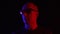 Bald man in dark glasses on black background in blue and red light. Portrait adult man in sunglasses in dark studio