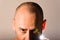 Bald man face portrait with freshly cut hair,  on background