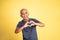 bald man forming a heart with finger gestures