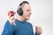 Bald man with headphones listens to music through a red apple player. Metaphor and concept of vitamin benefits in music and sound