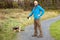 Bald man in his 40s walking on a path in a park with Yorkshire terrier on a leash. Concept animal care and outdoor activity,