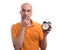 Bald man holding an alarm clock and thinking