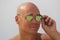 Bald man in mirror sunglasses. A beautiful tanned man on vacation, smiling. Portrait of a man close-up. Palm trees and the beach